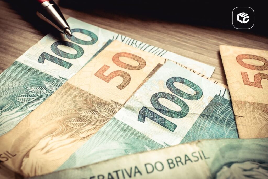 Notas de 100 e 50 reais brasileiras sobre superfície de madeira